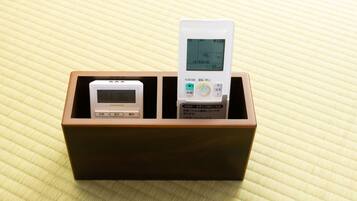 A wooden box containing two electronic devices with screens and buttons, placed on a textured surface.
