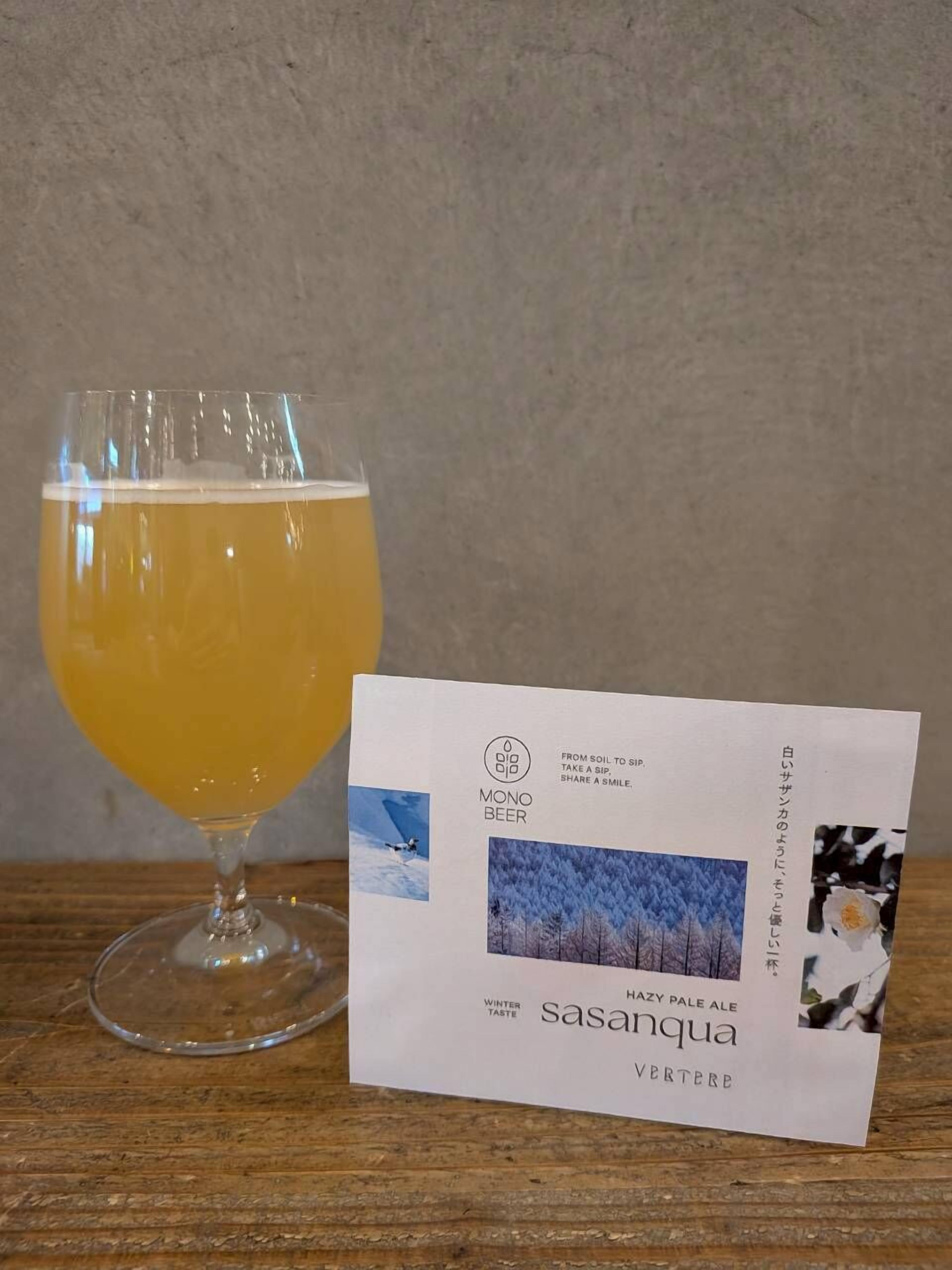 Un vaso de cerveza junto a un posavasos con texto e imágenes.