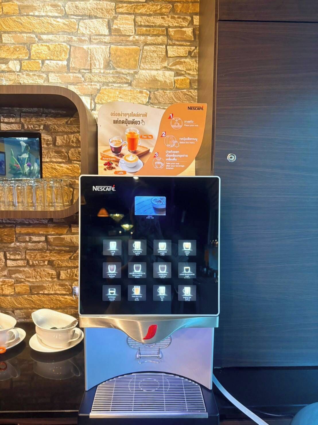 A Nescafe coffee machine with a touchscreen interface, a menu display, and a selection of coffee options.