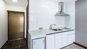 Una cocina moderna con azulejos blancos tipo metro, electrodomésticos de acero inoxidable y lavavajillas integrado.