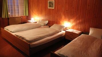 Ein Doppelbett mit zwei Nachttischen, einem Beistelltisch und einem kleinen Tisch mit Lampe.