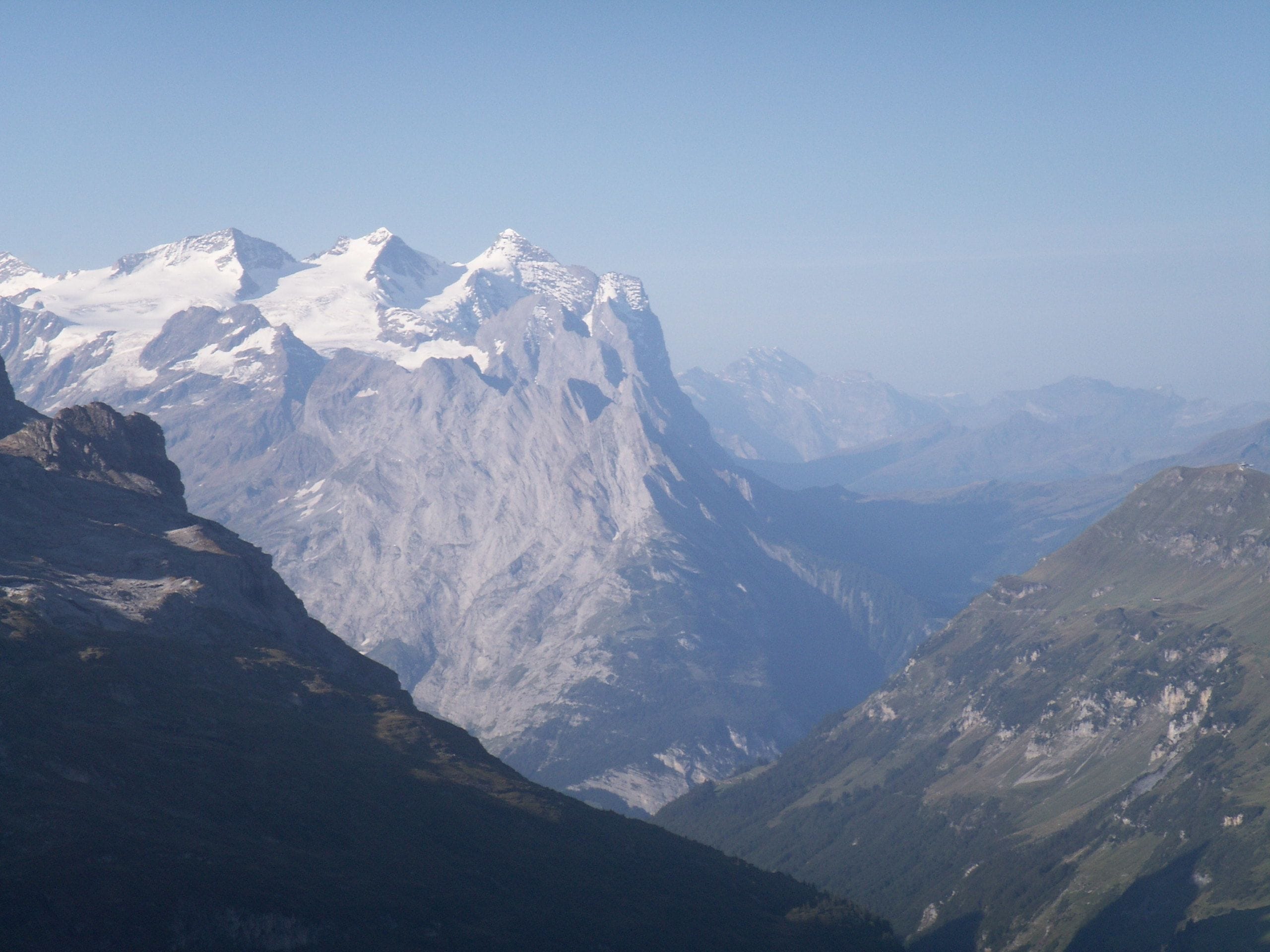 A mountainous landscape with snow-capped peaks and a valley.