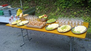 Ein Tisch im Freien, gedeckt mit Speisen und Weingläsern.