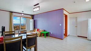 Un coin repas comprenant une table et des chaises, un canapé, une petite table et une vue par la fenêtre.