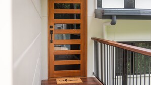 A wooden door with a glass panel and a welcome mat.
