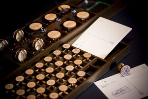 A vintage typewriter with a sheet of paper and a stamp.