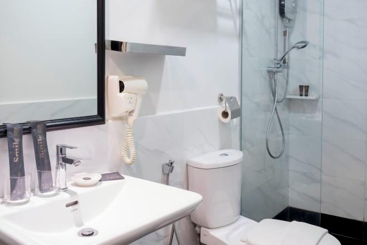 A modern bathroom with a sink, toilet, and shower.