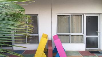 Fachada de edificio con grandes ventanales y suelo de baldosas.