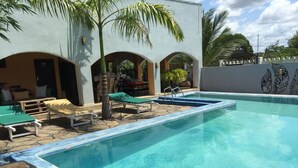 A swimming pool with lounge chairs and a palm tree. - Ritam Getaways (Tiwi)