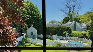 Une pelouse bien entretenue, une clôture blanche en bois et une piscine, le tout situé dans un quartier résidentiel.