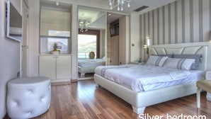 Een ruime slaapkamer met een groot bed, een kaptafel en een spiegel.