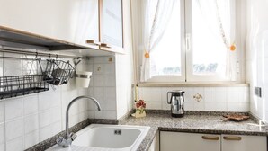 Cozinha com pia, torneira, bancada e armários.