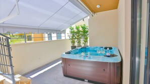 A hot tub on a balcony with a covered area, potted plants, and a staircase. - Split Luxury Collection (Split)