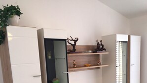Ein modernes Wohnzimmer mit Fernseher, Holzausstattung und einem Spiegel.
