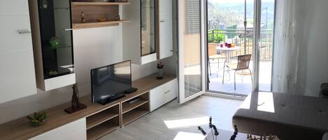 Apartamento família, várias camas, vista para o pátio | Área de estar | TV de tela plana