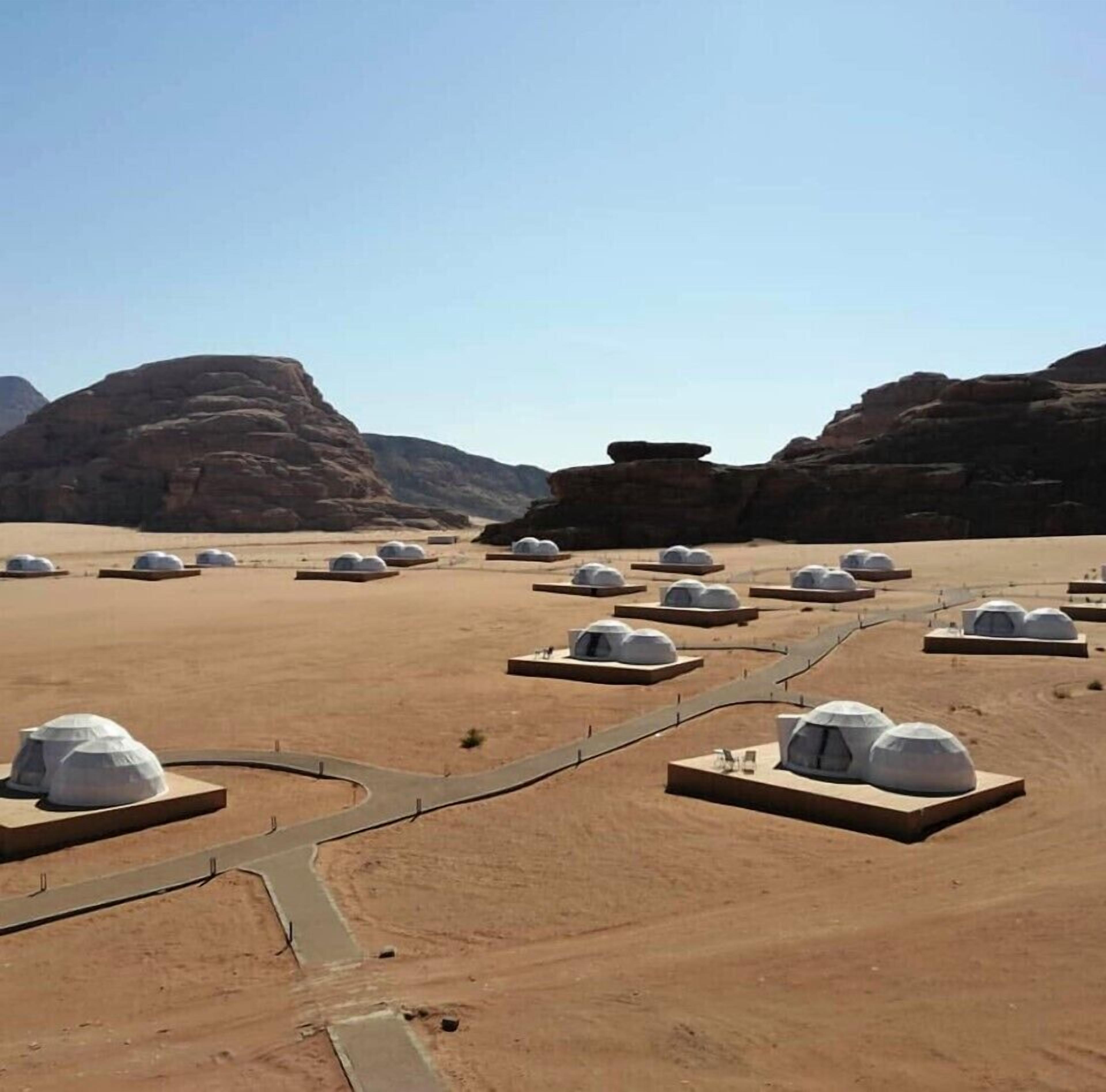 Paesaggio desertico con diverse strutture a forma di cupola disposte regolarmente.