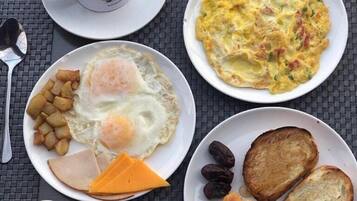 A breakfast tray with eggs, toast, ham, cheese, and a cup of coffee.