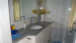 A bathroom with a sink, mirror, and a vase of flowers on the countertop. - Elisabetta Rapallo's house (Rapallo)