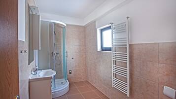 A modern bathroom with a glass-enclosed shower, a built-in sink, and a towel rack.
