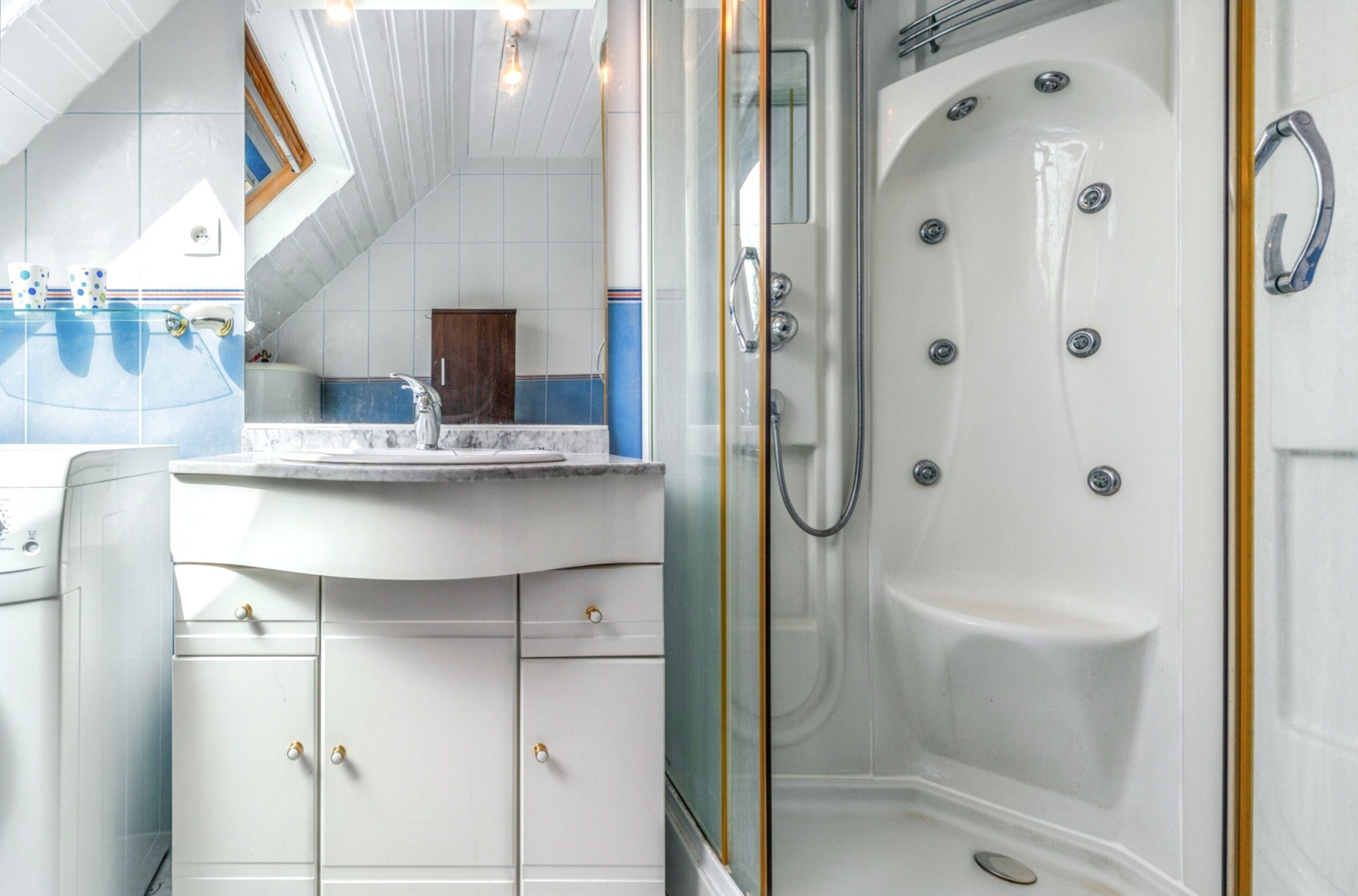 Une salle de bain avec un meuble-lavabo blanc, une grande baignoire et un espace douche.