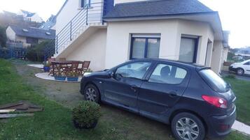 A two-story house with a car parked in the driveway.