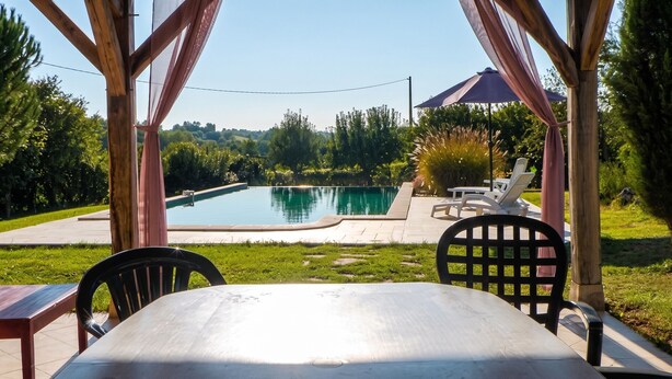 A covered outdoor area with a pool, chairs, and a table. - Homerez - Villa in Issac (Issac)