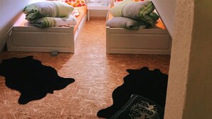 A small attic bedroom with two single beds, a window, and a white ceiling. - Little break (Gossersweiler-Stein)