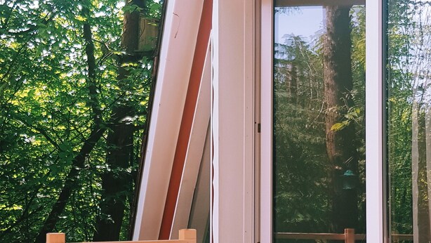 A wooden deck with two potted plants, a wooden ladder, and a sliding glass door leading to an outdoor area with a table and chairs. - Little break (Gossersweiler-Stein)