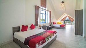 A spacious bedroom with a large bed, a smaller bed, and a seating area with a view of the outdoors. - Blue Boutique Villa Hoi An (Da Nang)