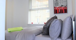 Tabla de planchar con plancha y ropa de cama 