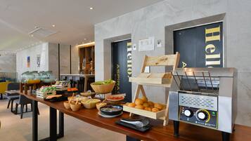 A buffet setup with various food items and a coffee machine.