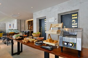A buffet setup with various food items and a coffee machine. - Aspira One Sutthisan (Bangkok)