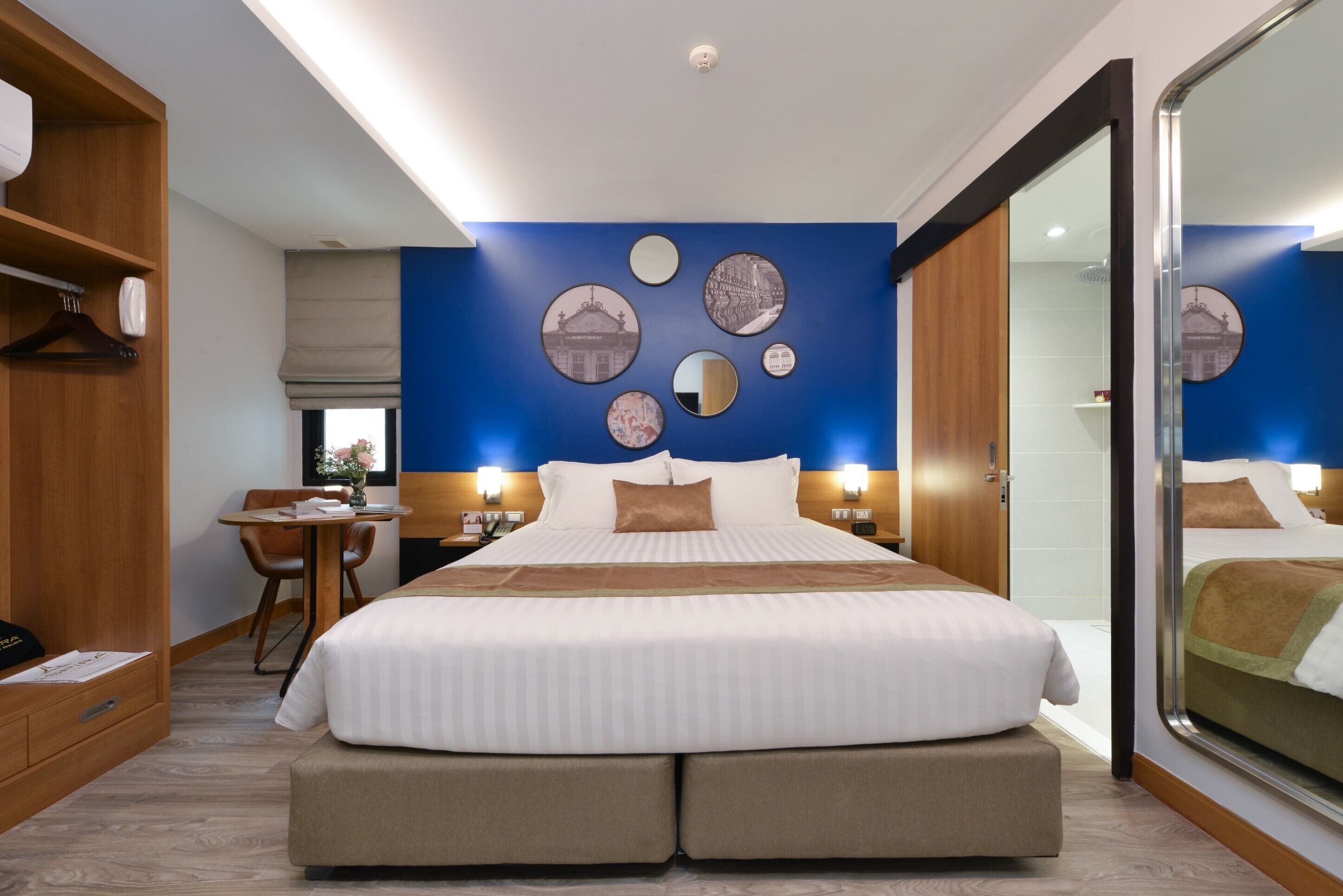 Una habitación de hotel con una cama grande, un escritorio y una silla.
