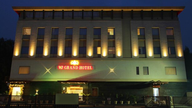 Hotelli, jonka yläpuolella on suuri, punainen kyltti, jossa lukee: ”WJ GRAND HOTEL”.