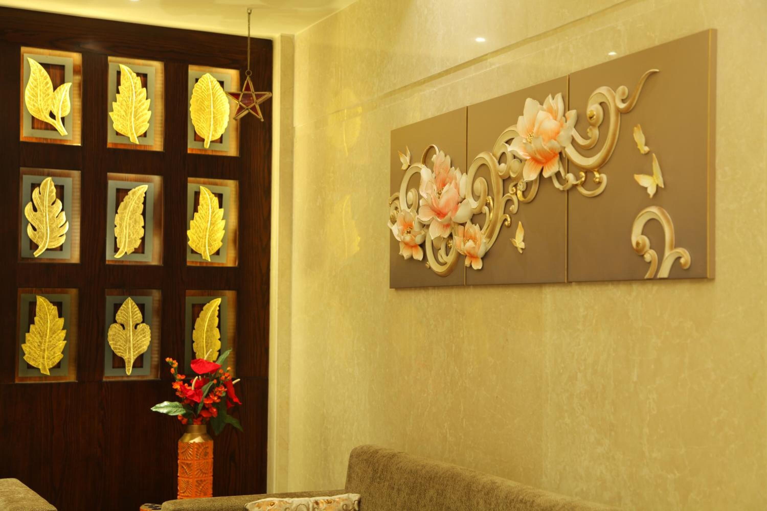 Una habitación con pared de madera oscura adornada con detalles en pan de oro y una gran obra de arte floral.