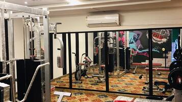 A gym with various exercise equipment, including a treadmill, stationary bike, and weight machines.