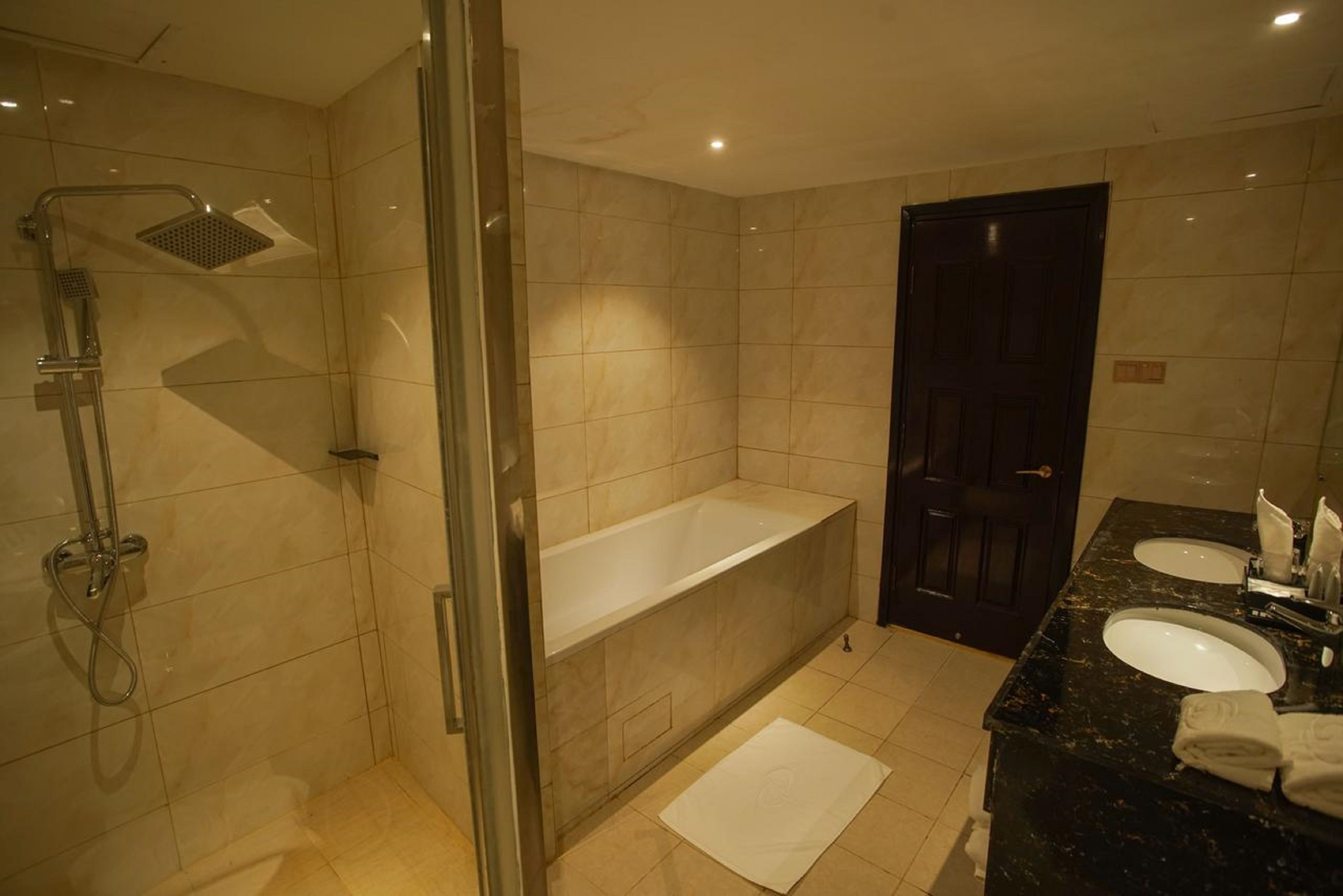 Un bany modern amb dutxa envidriada, banyera independent i un lavabo amb doble rentapel.