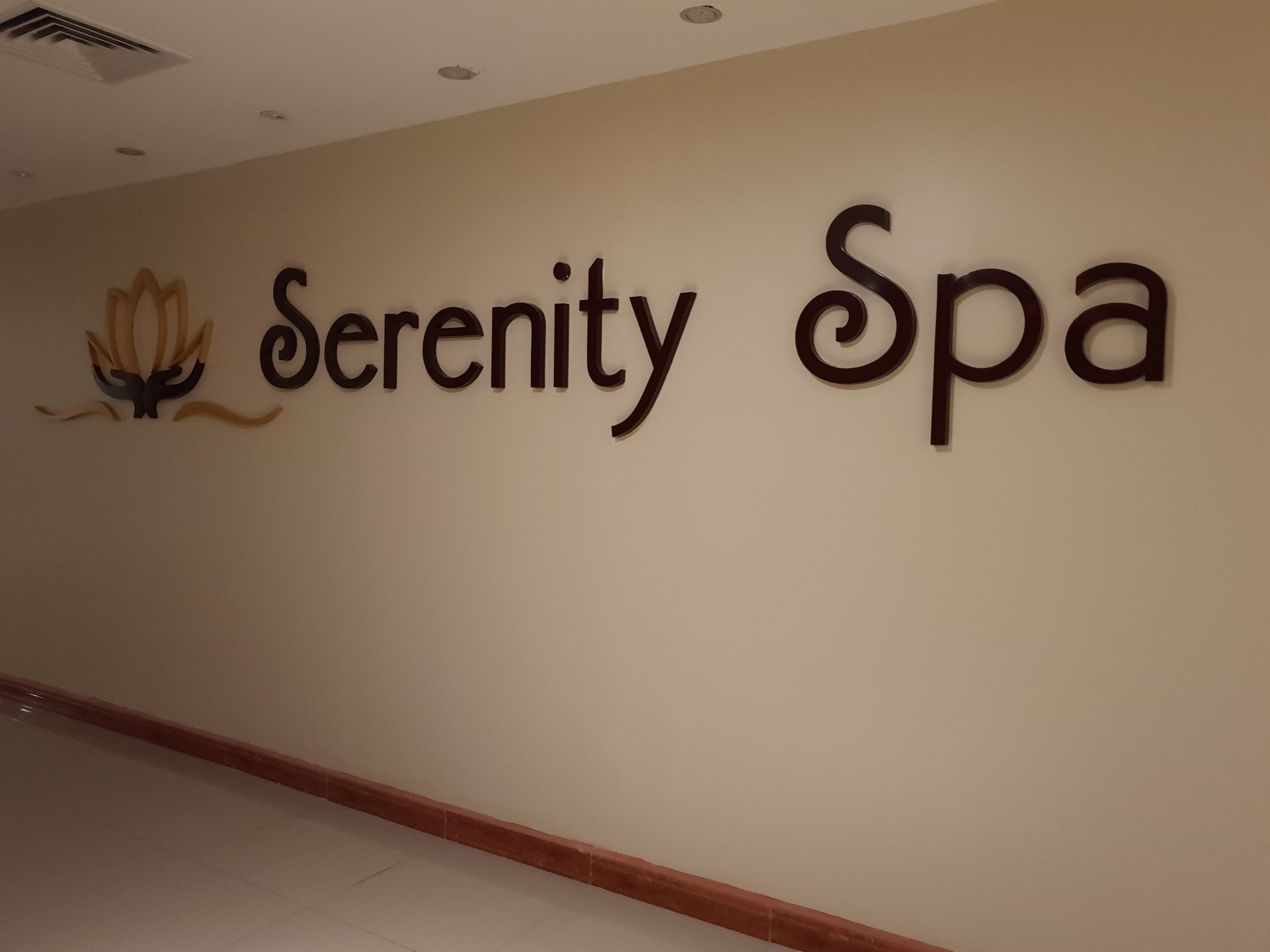 A wall with the words "Serenity Spa" and a lotus flower symbol.