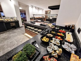 A buffet setup with various food items and condiments.