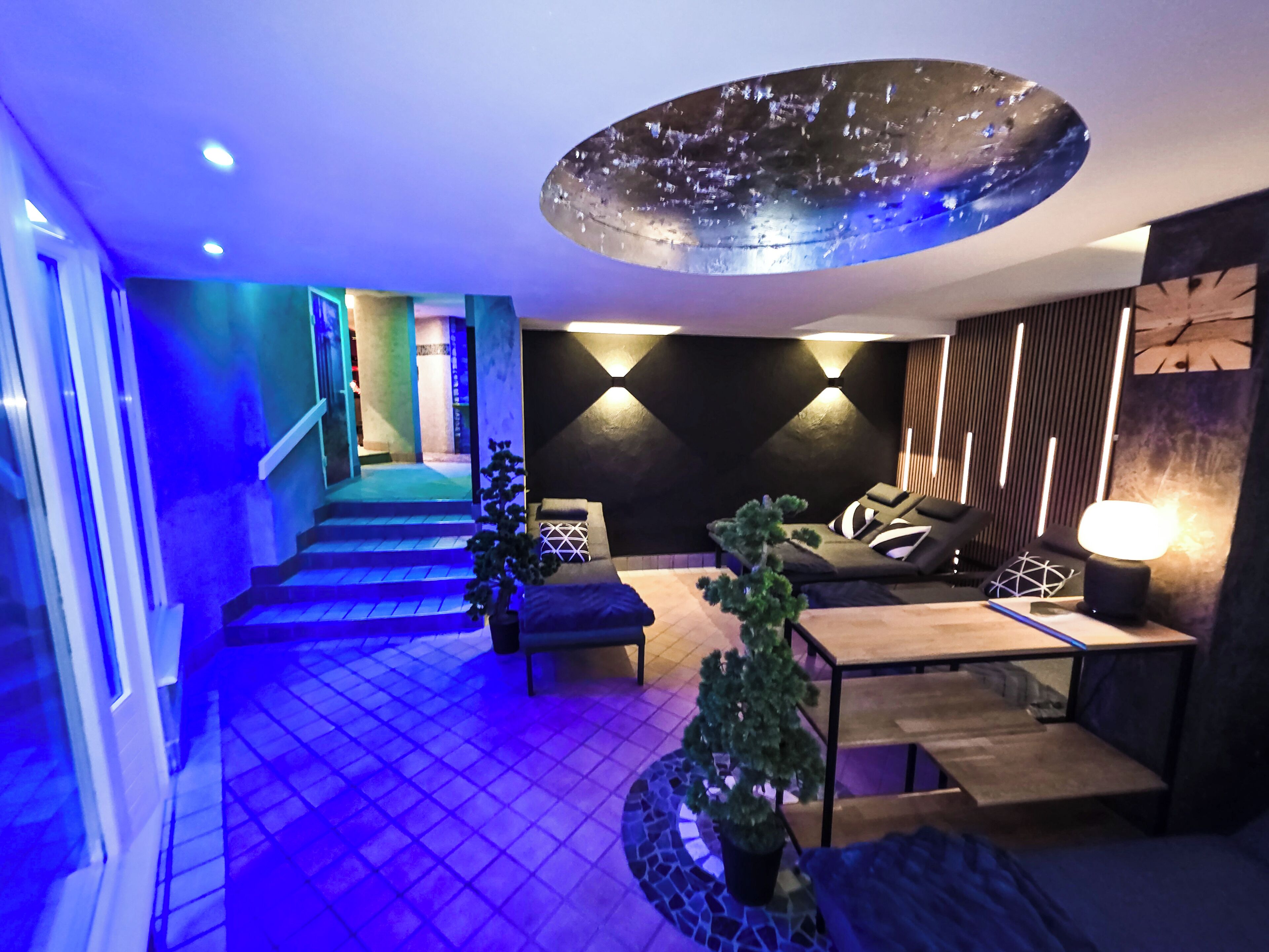 Ein modernes Interieur mit Treppe, Sitzgelegenheit und einer Deckenleuchte.