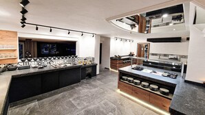 A modern kitchen with a central island, built-in appliances, and a mezzanine level with a dining area.