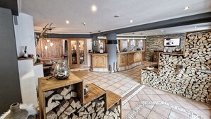 A spacious living area with a kitchen, wooden cabinets, a fireplace, and a television.