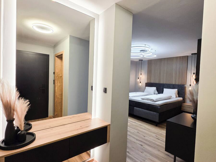 Une chambre à coucher moderne avec un lit, des tables de chevet et un grand miroir.