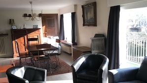 Un salon comprenant un coin repas, un lustre et une vue sur l’extérieur.