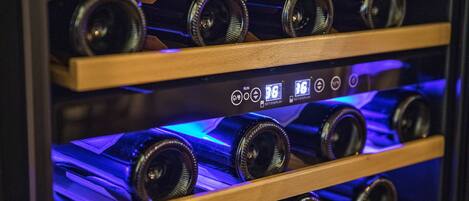A wine rack with bottles and a control panel with buttons and a display.