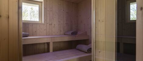 Un sauna en bois avec des bancs et une fenêtre.