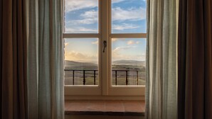 Una habitación con un ventanal grande, una puerta y vistas al paisaje.
