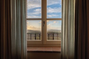 Una habitación con un ventanal grande, una puerta y vistas al paisaje.