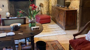 A cozy living room with a fireplace, a dining table, and a comfortable seating area.