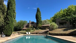 A swimming pool with a stone house in the background.